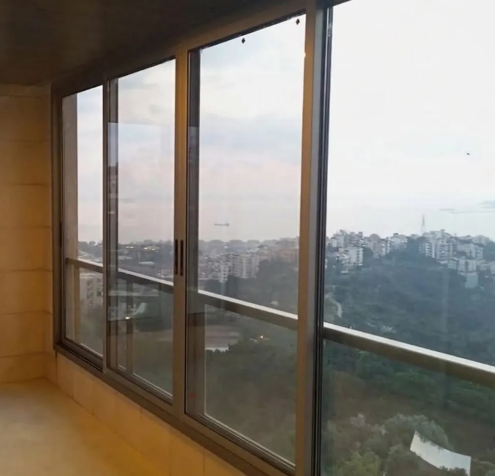 Bronze aluminium sliding doors opening onto a valley view