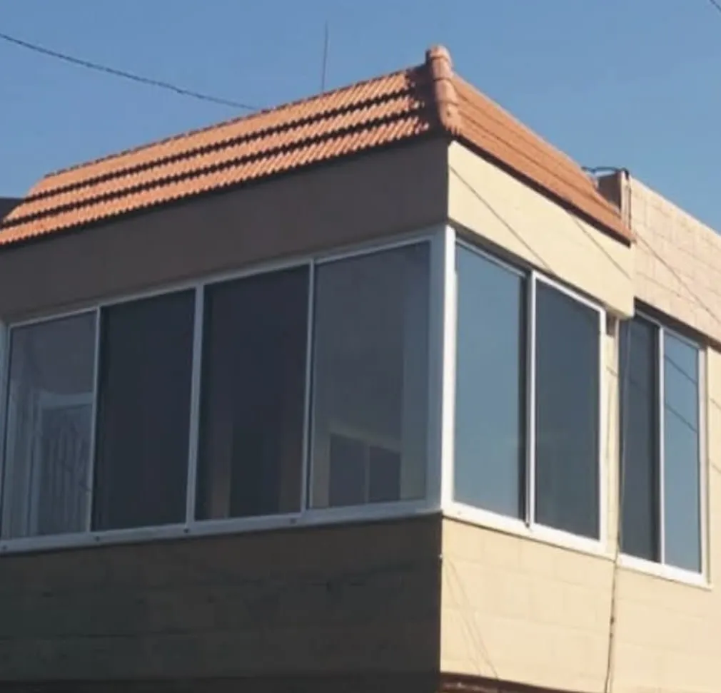Corner balcony enclosure under a red-tile roof