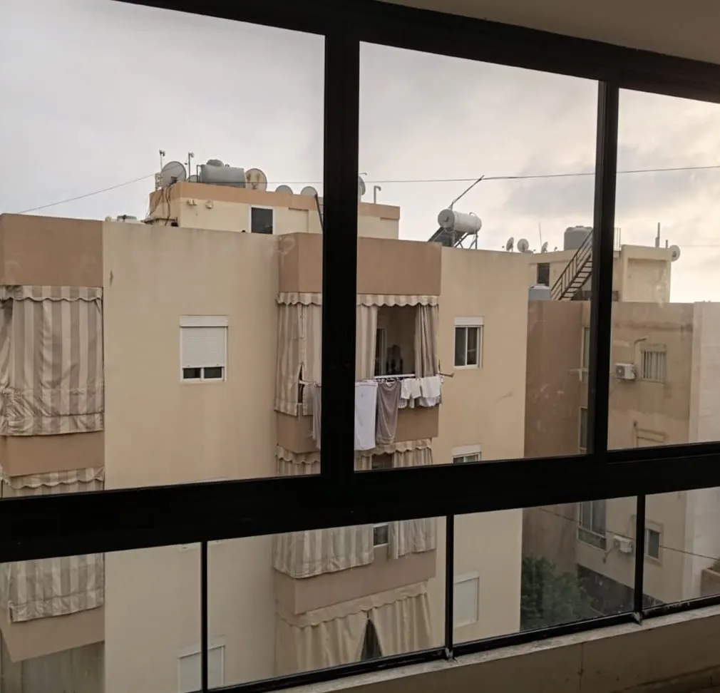 Black-frame balcony enclosure looking across neighbouring buildings