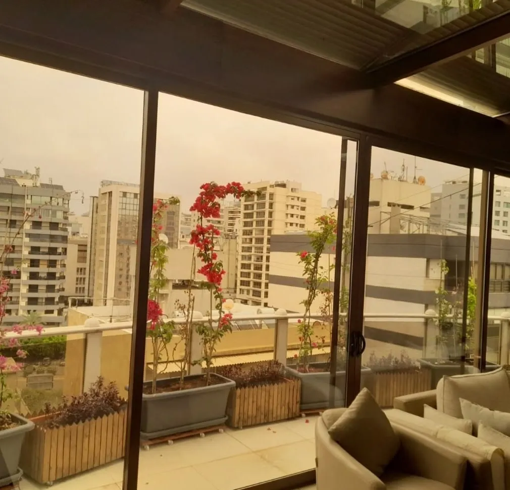 Glazed terrace enclosure with planters and city view
