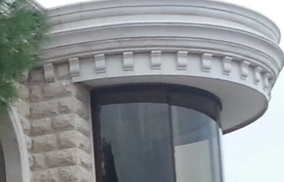 Curved glass facade in the round bay of a cut-stone villa